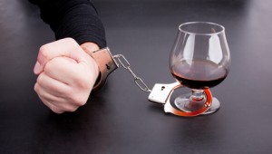 Hand locked to glass of alcohol Hand locked to glass of alcohol