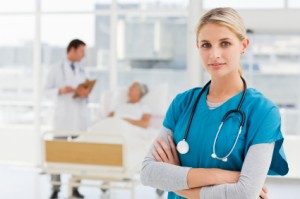 Young doctor standing while colleague talking to patient in back